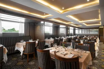 a restaurant with tables and chairs in a room at Jaz Elite Regent Nile Cruise - Every Monday from Luxor for 07 & 04 Nights - Every Friday From Aswan for 03 Nights in Luxor