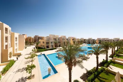 an overhead view of a pool with palm trees and buildings at Jazzy 1BDR w Outdoor Pool View Terrace Free Pool & Beach Access in Hurghada