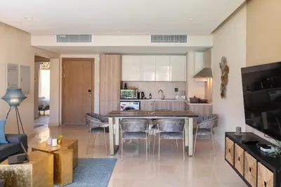 a kitchen and living room with a table and chairs at Elegant & Edgy 2 BR w Beach & Pool Mangroovy in Hurghada