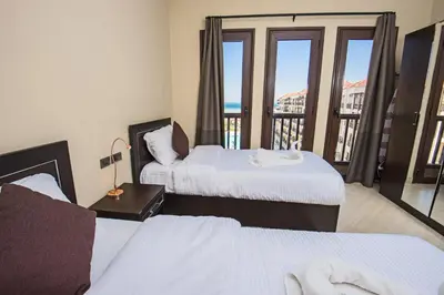 a hotel room with two beds and a balcony at Premium sea view 2 bedrooms 2 bathrooms apartment located within Gravity Hotel & Aquapark Hurghada in Hurghada