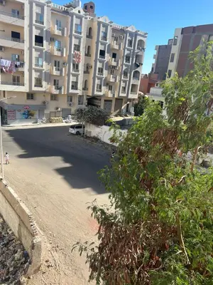 an empty street in front of a large apartment building at Hossam Deluxe Apartment El Hadaba Sheraton in Hurghada