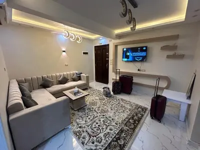 a living room with a couch and a tv at Hossam Deluxe Apartment El Hadaba Sheraton in Hurghada