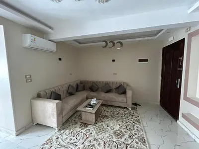 a living room with a couch and a table at Hossam Deluxe Apartment El Hadaba Sheraton in Hurghada