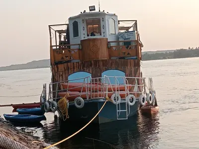 a boat tied to a dock in the water at Houseboat Hotel and Nile Cruises Zainoba in Aswan