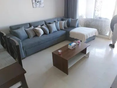 a living room with a blue couch and a coffee table at MCJ Luxury 2 Bedrooms Apartment in Hurghada