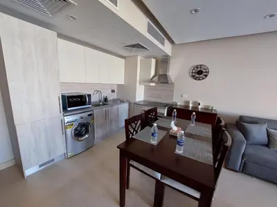 a living room with a table and a kitchen at MCJ Luxury 2 Bedrooms Apartment in Hurghada