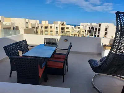 a patio with a table and chairs on a balcony at MCJ Luxury 2 Bedrooms Apartment in Hurghada