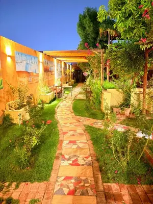 a walkway in a garden with flowers and plants at Nile Compound in Luxor