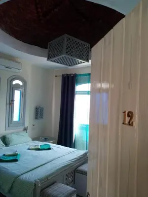 a bedroom with a large bed and a window at Nile Compound in Luxor