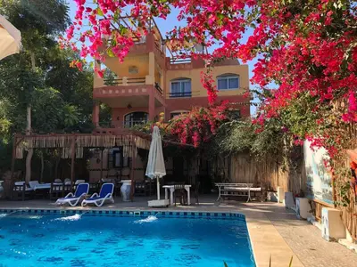 a resort with a swimming pool and a building at Nile Compound in Luxor