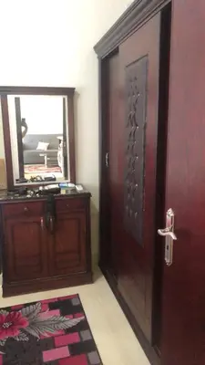 a wooden door in a room with a mirror at Red Sea Tiba plaza Apartment in Hurghada