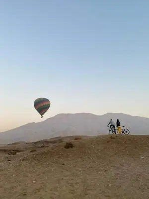two people on a hill with a hot air balloon at Nour El Balad in Luxor