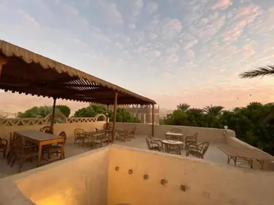 a patio with tables and chairs on a roof at Nour El Balad in Luxor