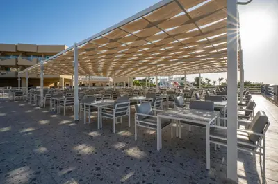 a patio with tables and chairs under a canopy at Seven Seas Jolie Bay - Ultra All Inclusive in Hurghada