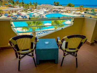 a table and chairs on a balcony with a view of a resort at Seven Seas Jolie Bay - Ultra All Inclusive in Hurghada