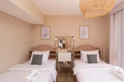 a bedroom with two beds and a chandelier at Dashing 2 BDR Mangroovy Free Pool & Beach Access in Hurghada