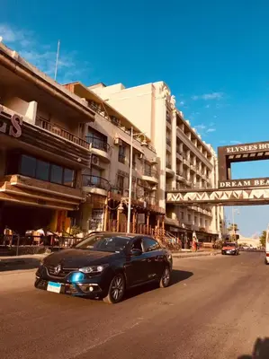 a black car driving down a street in front of a building at Palma house apartments A8 in Hurghada