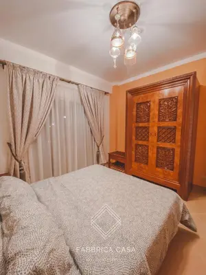 a bedroom with a bed and a wooden cabinet at Beautiful 1 bedroom apartment in Quseir