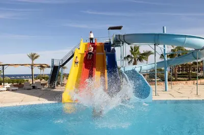 a person on a slide in a swimming pool at Bliss Nada Beach Resort in Coraya Bay