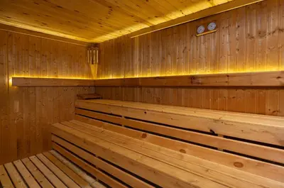 a wooden sauna with wooden benches and a clock at Bliss Nada Beach Resort in Coraya Bay