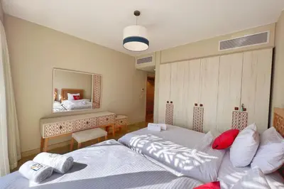 a bedroom with two beds and a mirror at Homestyle 3BR Penthouse Pool & Beach View in Hurghada
