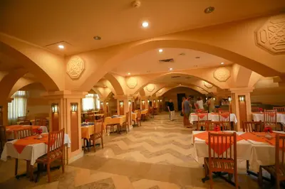 a restaurant with tables and chairs and people in the background at Marina view port ghalib in Port Ghalib