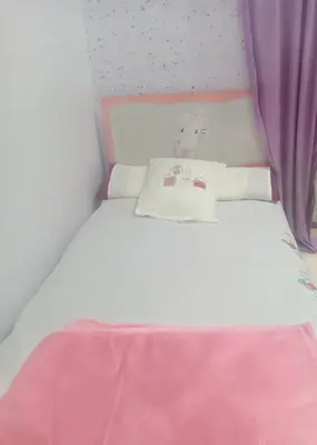 a white bed with a pink blanket and pillows at Yasin - Enjoy the privacy of staying in a quiet apartment with free Wi-Fi as your complete second home in the heart of Hurghada in Hurghada