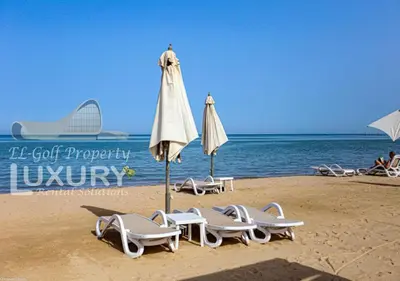 a group of chairs and an umbrella on a beach at Mangarov-2BR. M1-6b-12 in Hurghada