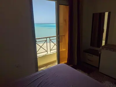 a bedroom with a view of the ocean from a window at Casablanca resort in Hurghada