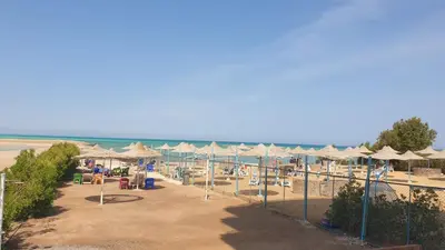 a beach with umbrellas and chairs and the ocean at Casablanca resort in Hurghada