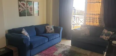 a blue couch in a living room with a window at Casablanca resort in Hurghada