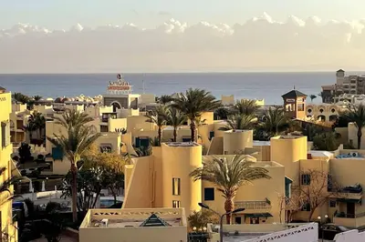 a city with buildings and palm trees and the ocean at Florenza Khamsin - sea view / free Wi-Fi in Hurghada