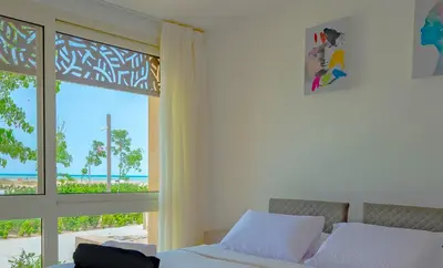 a bedroom with a bed and a view of the ocean at Ollystays Mangroovy Seaview 3BR Beach and Pool Free access in Hurghada