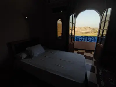 a bedroom with a bed in a room with a window at Ahmed Mulatam House in Luxor