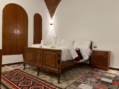 a bedroom with a bed and a wooden dresser at Luxor Villa Hatshepsut in Luxor