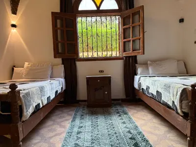 two beds in a room with a window at Luxor Villa Hatshepsut in Luxor