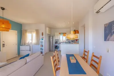 a living room with a couch and a table and chairs at Sunny 2 Bedroom + Private Roof Terrace Lagoon View in Hurghada