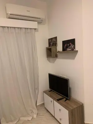 a living room with a flat screen tv on a stand at Aqua Palms Resort by Ivan C408 in Hurghada