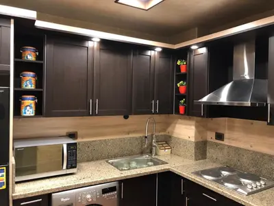 a kitchen with wooden cabinets and a sink and a microwave at VIVA Andalouse luxury family suite, private beach & pool, NO ORFI in Hurghada