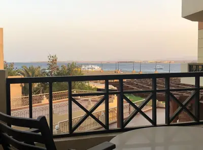 a balcony with a view of the beach and the ocean at VIVA Andalouse luxury family suite, private beach & pool, NO ORFI in Hurghada
