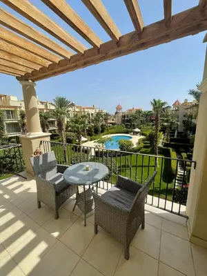 a patio with a table and chairs and a view of a pool at Apartman Veranda in Hurghada