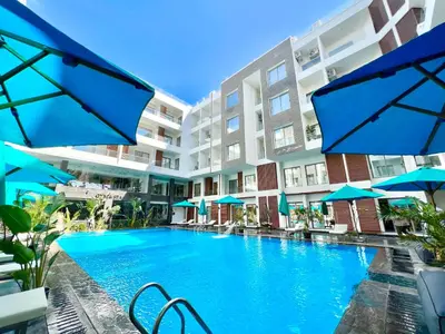 a swimming pool in front of a building with blue umbrellas at Imperial Resort Hurghada in Hurghada