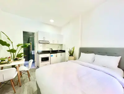 a white bedroom with a large bed and a table at Imperial Resort Hurghada in Hurghada