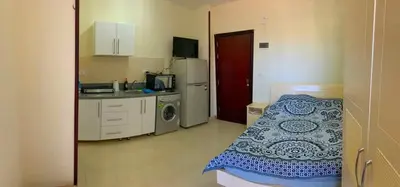 a small room with a bed and a kitchen at Прекрасная студия в комплексе с бассейном рядом с бесплатным пляжем in Hurghada