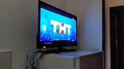 a flat screen tv sitting on top of a dresser at Прекрасная студия в комплексе с бассейном рядом с бесплатным пляжем in Hurghada
