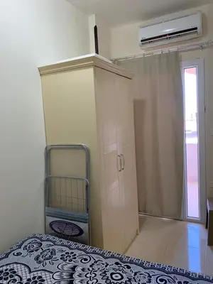 a bedroom with a bed and a cabinet and a window at Прекрасная студия в комплексе с бассейном рядом с бесплатным пляжем in Hurghada