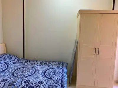 a bedroom with a bed next to a cabinet at Прекрасная студия в комплексе с бассейном рядом с бесплатным пляжем in Hurghada