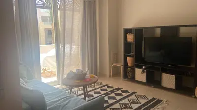 a living room with a flat screen tv and a living room at Mangroovy Gouna 1 BR apartment in Hurghada