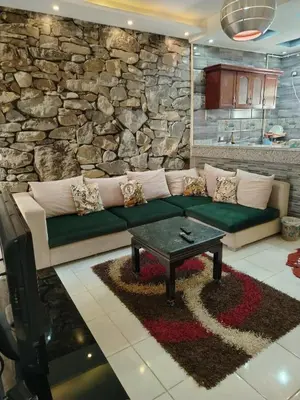 a living room with a couch and a stone wall at Paradise Hill Compound in Hurghada
