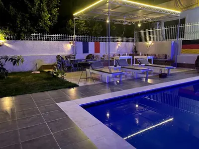 a swimming pool at night with a patio and a table at Luxor Oasis Guest House in Luxor